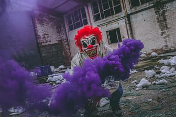 Conheça o significado dos termos ware 4 clown holding purple smoke bomb in ruined building